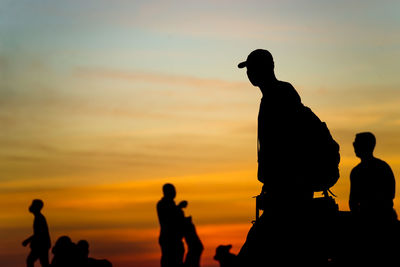 Silhouette people statue against sky during sunset