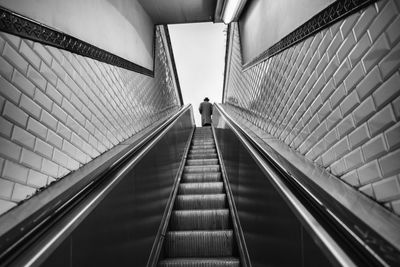 Low angle view of man standing on escalator