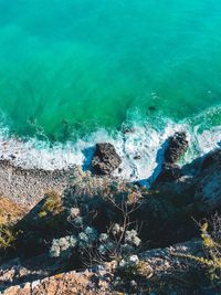 High angle view of sea waves splashing on rocks