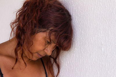 Close-up sad of woman against wall