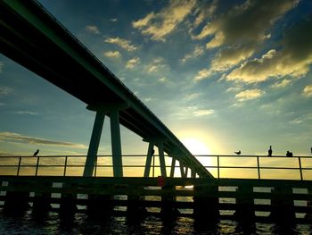 Low angle view of bridge against sky during sunset