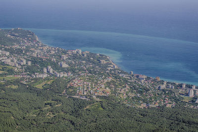 High angle view of townscape by sea against sky