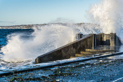 Waves crash on the waterfront at alki beach in west seattle, washington.