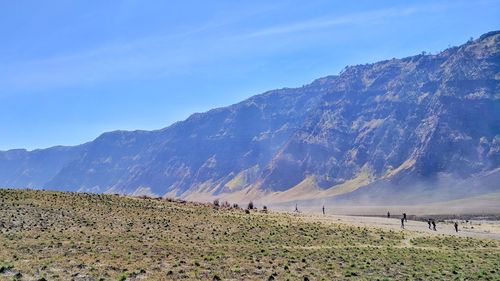 Scenic view of land and mountains against sky