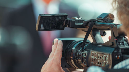 Camera at a media press conference publicity outdoors.