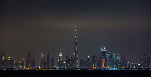 Illuminated buildings against sky at night