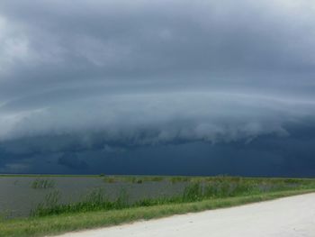 Road by field against sky