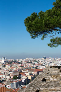 High angle view of cityscape by sea against clear sky