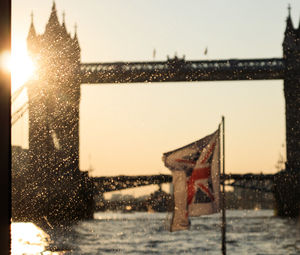 Sun shining over frozen lake against clear sky during winter