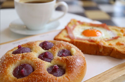 Closeup of sweet potato puree bun with blurry french toast and coffee in the backdrop