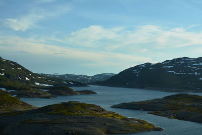 Scenic view of lake by mountains against sky