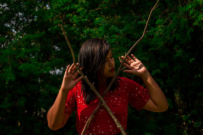 Young woman holding sticks on field