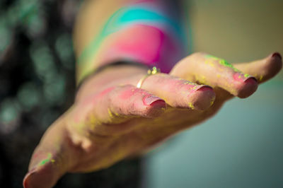 Close-up of hand holding pink flower
