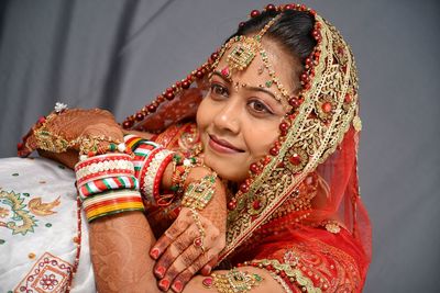 Close-up of smiling young bride standing against wall