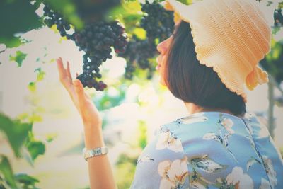 Woman by grapes on vineyard