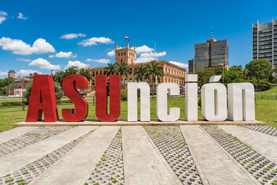 Text on building against cloudy sky