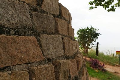View of stone wall with trees in background