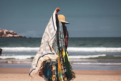 Person on beach against sky