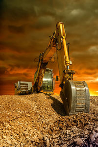 Construction site on field against sky during sunset