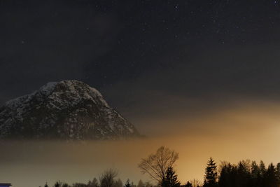 Low angle view of snowcapped mountain against sky at night