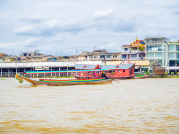 Boats moored on sea against buildings