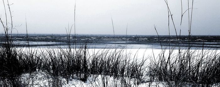 Frozen lake against sky during winter