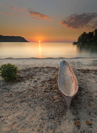 Wooden boat on the sand at sunset on deere beach