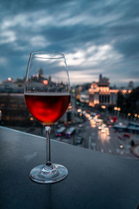 Close-up of beer in wineglass against sky at dusk