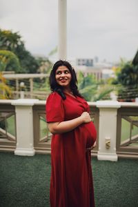 Thoughtful pregnant woman standing against clear sky