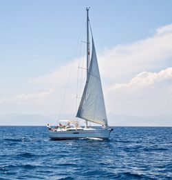 Sailboat sailing on sea against sky