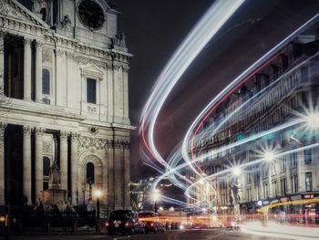 Light trails on street against buildings at night