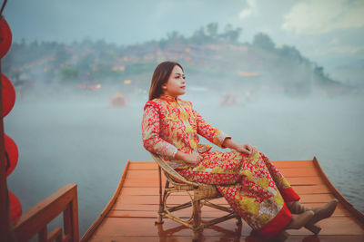 Asian woman wearing cheongsam traditional red dress on chinese new year travel.