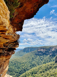 Rock formations by mountains against sky