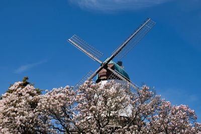 Low angle view of traditional windmill against blue sky