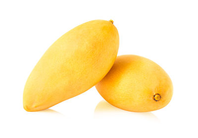 Close-up of yellow fruit over white background