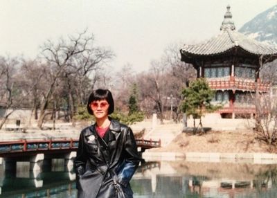 Portrait of young woman standing by railing