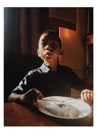 Portrait of young man sitting at table