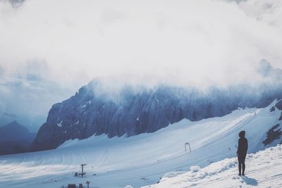 People skiing on snow covered landscape