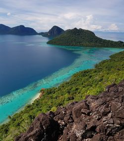 Scenic view of sea and mountains against sky