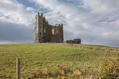 Old ruins on field against sky