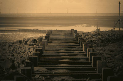 Boardwalk against sky during sunset