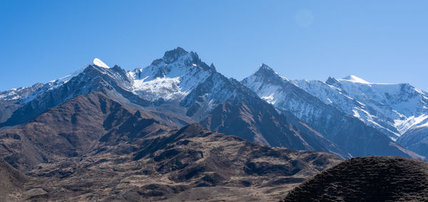 Scenic view of snowcapped mountains against clear blue sky