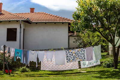 Clothes drying outside house against sky