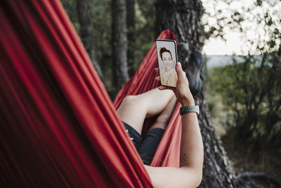 Woman video calling female friend through mobile phone during vacation