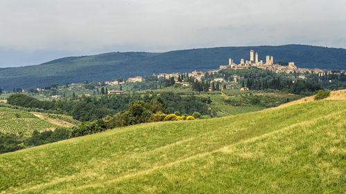 Scenic view of field and buildings against sky