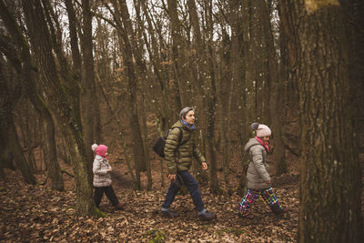 Children playing with trees in forest