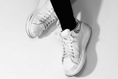 Low section of person wearing shoes over white background