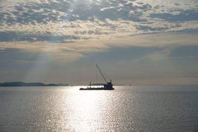 Sailboat sailing on sea against sky during sunset