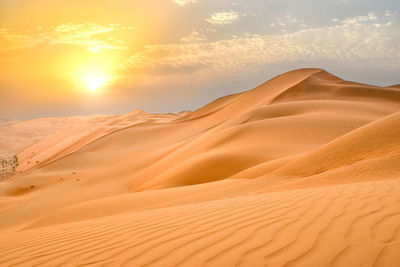 Scenic view of desert against sky during sunset