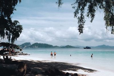 People on beach against sky